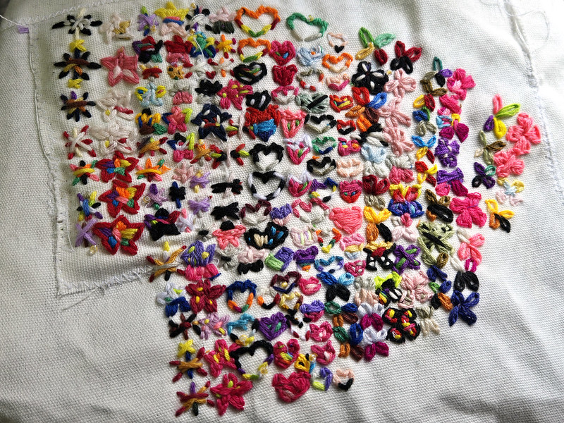 A poorly planned shape made out of little pairs of colorful embroideries